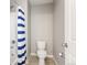 This bathroom has a toilet, tub and a blue striped shower curtain at 2248 Rosette Ln, Castle Rock, CO 80104