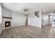 Open living room with fireplace, neutral paint, wood floors, ceiling fan and access to other living areas at 2248 Rosette Ln, Castle Rock, CO 80104