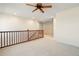 Upstairs loft area with neutral carpet, wood banister, fan and access to other rooms at 2388 W 165Th Pl, Broomfield, CO 80023
