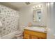 Cozy bathroom with patterned shower curtain, white walls, and wood vanity with ample lighting at 9642 Meade Ct, Westminster, CO 80031