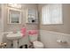 Charming bathroom with a pedestal sink, toilet, and built-in storage shelves at 9642 Meade Ct, Westminster, CO 80031