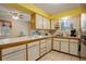 Bright kitchen with white cabinets, tile countertops, and a view into the dining area at 9642 Meade Ct, Westminster, CO 80031