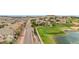 Aerial view of the home, neighborhood street, golf course, and pond with a beautiful mountain backdrop at 10061 Bluffmont Ct, Lone Tree, CO 80124