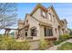 Stunning two-story home showcasing a stucco exterior, decorative shutters, and a spacious outdoor patio with stone accents at 10061 Bluffmont Ct, Lone Tree, CO 80124