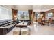 Bright living room features large windows, dark leather sofas, and stylish decor, perfect for relaxing or entertaining guests at 10061 Bluffmont Ct, Lone Tree, CO 80124