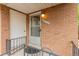 Up-close shot of a brick entrance with a screen door, house number, and iron railing at 9824 Lane St, Thornton, CO 80260
