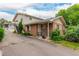 Inviting brick townhome with well-maintained landscaping, a covered porch, and convenient parking at 9824 Lane St, Thornton, CO 80260