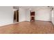 Open living area features wood-look floors, neutral walls, and a glimpse of the kitchen at 9824 Lane St, Thornton, CO 80260