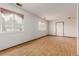 Bright living room with wood-look flooring, large windows, and neutral color palette at 9824 Lane St, Thornton, CO 80260