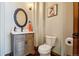 Charming powder room featuring a stylish vanity with a unique oval mirror and modern fixtures at 10441 Carriage Club Dr, Lone Tree, CO 80124