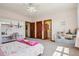 A bedroom featuring pink walls, plush carpeting, a fan, and lots of natural light from the window at 10441 Carriage Club Dr, Lone Tree, CO 80124