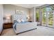 Bright bedroom with a tufted headboard, neutral tones, balcony access, and large windows for natural light at 10441 Carriage Club Dr, Lone Tree, CO 80124
