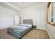 Bright bedroom featuring a gray platform bed with white and blue bedding, a window, and neutral carpet at 10441 Carriage Club Dr, Lone Tree, CO 80124