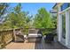 Outdoor deck area with comfortable wicker furniture, perfect for relaxing and entertaining, surrounded by lush trees at 10441 Carriage Club Dr, Lone Tree, CO 80124