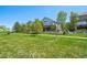Exterior view of a home with a large lawn and a white fence on a sunny day, showcasing curb appeal at 10441 Carriage Club Dr, Lone Tree, CO 80124