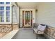 Inviting front porch with a decorative glass door, stone accents and a cozy bench seating at 10441 Carriage Club Dr, Lone Tree, CO 80124