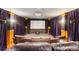 Home theater features plush leather seating, a projection screen, a projector, and moody purple drapes at 10441 Carriage Club Dr, Lone Tree, CO 80124