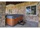 Covered outdoor hot tub area with stone walls, providing a private and relaxing spa experience at 10441 Carriage Club Dr, Lone Tree, CO 80124