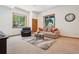 A cozy living room with a comfortable sofa, arm chair, area rug, and large windows at 10441 Carriage Club Dr, Lone Tree, CO 80124
