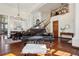 Bright living room showcasing hardwood floors, elegant chandeliers, a grand piano, staircase, and dining area at 10441 Carriage Club Dr, Lone Tree, CO 80124