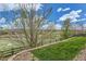 Scenic backyard view featuring a fenced yard, lush green grass, and an open horizon under a blue sky at 4406 Sidewinder Loop, Castle Rock, CO 80108