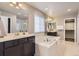 Luxurious bathroom featuring dual vanities, soaking tub, glass-enclosed shower, and walk-in closet at 4406 Sidewinder Loop, Castle Rock, CO 80108