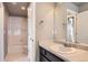 Bathroom featuring a vanity with dark cabinetry, a large mirror, and a combined shower and tub at 4406 Sidewinder Loop, Castle Rock, CO 80108