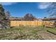 A fenced backyard with green grass, and room for activities at 12995 W Chenango Ave, Morrison, CO 80465