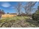 A fully fenced backyard featuring a small grassy area and mature trees at 12995 W Chenango Ave, Morrison, CO 80465