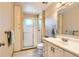 Bathroom with a glass-enclosed shower, neutral tile, and a vanity with a white countertop at 12995 W Chenango Ave, Morrison, CO 80465