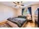 Neutral-colored bedroom featuring hardwood floors, a ceiling fan, and a large window at 12995 W Chenango Ave, Morrison, CO 80465