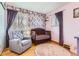 Charming Bedroom with floral wallpaper and a tufted glider, creating a cozy atmosphere at 12995 W Chenango Ave, Morrison, CO 80465