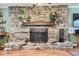 Close up of the stone fireplace, with wooden mantle and iron grate at 12995 W Chenango Ave, Morrison, CO 80465