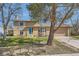 Inviting two-story home featuring a charming blue front door and well-manicured lawn at 12995 W Chenango Ave, Morrison, CO 80465