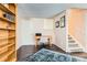 This home office features a built-in bookshelf, desk, and stairs to another level at 12995 W Chenango Ave, Morrison, CO 80465