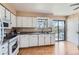 Functional kitchen featuring white cabinetry, wood-look floors, and a sliding glass door to backyard at 12995 W Chenango Ave, Morrison, CO 80465