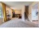 Spacious carpeted living room with a view into the kitchen and staircase to the second floor at 12995 W Chenango Ave, Morrison, CO 80465