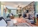 Inviting living room with a stone fireplace, wood floors, and plenty of natural light at 12995 W Chenango Ave, Morrison, CO 80465
