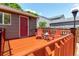 Cozy back deck features outdoor seating, with a red door leading into the home's interior at 12908 Hudson St, Thornton, CO 80241