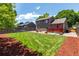 Spacious backyard featuring a well-maintained lawn, wooden deck, and a gravel area with seating, perfect for outdoor entertaining at 12908 Hudson St, Thornton, CO 80241