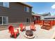 Backyard area with a fire pit, seating, rock landscape, and a two-story home at 12908 Hudson St, Thornton, CO 80241