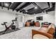 Finished basement featuring a home office setup, exposed ceiling, and a stationary bicycle for fitness at 12908 Hudson St, Thornton, CO 80241