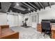 Finished basement featuring barn door, home office setup, exposed ceiling, and a stationary bicycle at 12908 Hudson St, Thornton, CO 80241