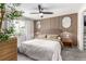 Bedroom with wood slat accent wall, ceiling fan, and oval mirrors at 12908 Hudson St, Thornton, CO 80241