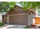Attached two-car garage with brick accents and well-kept landscaping, adding to the home's functionality and aesthetic appeal at 12908 Hudson St, Thornton, CO 80241
