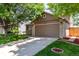 Two-car garage with well-kept lawn and landscaping, enhancing the home's curb appeal with easy access at 12908 Hudson St, Thornton, CO 80241