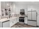 Bright kitchen with white cabinets, stainless steel appliances, and farmhouse sink at 12908 Hudson St, Thornton, CO 80241