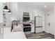 Modern kitchen featuring quartz countertops, stainless steel appliances, and sleek white cabinetry at 12908 Hudson St, Thornton, CO 80241