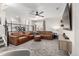 Spacious living room featuring comfortable seating, modern entertainment center, and sleek ceiling fan at 12908 Hudson St, Thornton, CO 80241