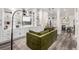 Modern living room with custom built-ins, sleek lighting, and comfortable green sectional sofa at 12908 Hudson St, Thornton, CO 80241